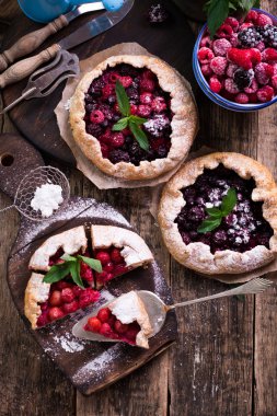 Yaban mersini, kiraz, ahududu ve blackcurrant Galette'ye w ahşap zemin üzerine.