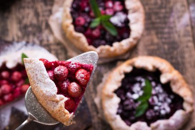 Yaban mersini, kiraz, ahududu ve blackcurrant Galette'ye w ahşap zemin üzerine.