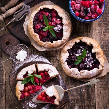 Yaban mersini, kiraz, ahududu ve blackcurrant Galette'ye w ahşap zemin üzerine.
