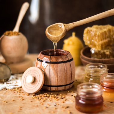 Arka plan tatlım. Doğal bal tarak, cam jarand ahşap kase. Ahşap rustik masanın üstünde. Yumuşak odak