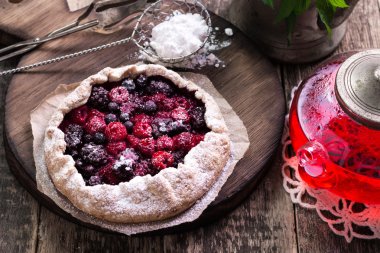 Yaban mersini, kiraz, ahududu ve blackcurrant Galette'ye w ahşap zemin üzerine.