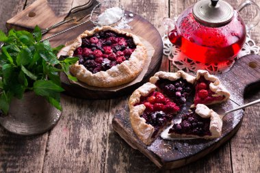 Yaban mersini, kiraz, ahududu ve blackcurrant Galette'ye w ahşap zemin üzerine.