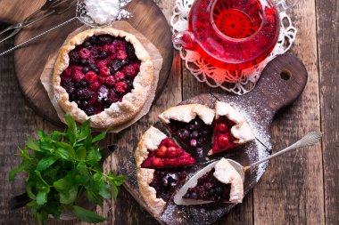 Yaban mersini, kiraz, ahududu ve blackcurrant Galette'ye w ahşap zemin üzerine.