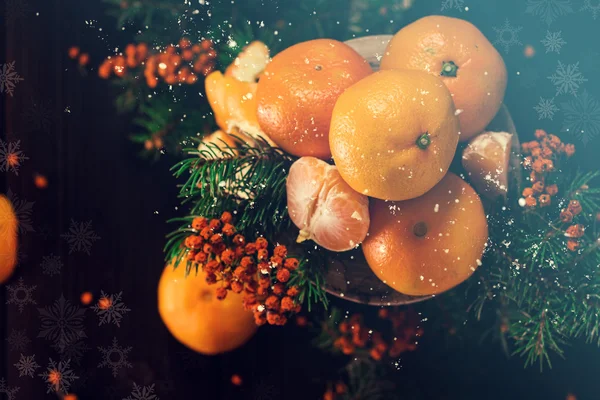 Christmas composition with tangerines and falling snow flakes. Christmas Card. — Stock Photo, Image