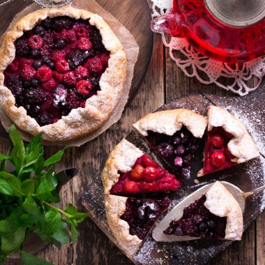Yaban mersini, kiraz, ahududu ve blackcurrant Galette'ye w ahşap zemin üzerine.