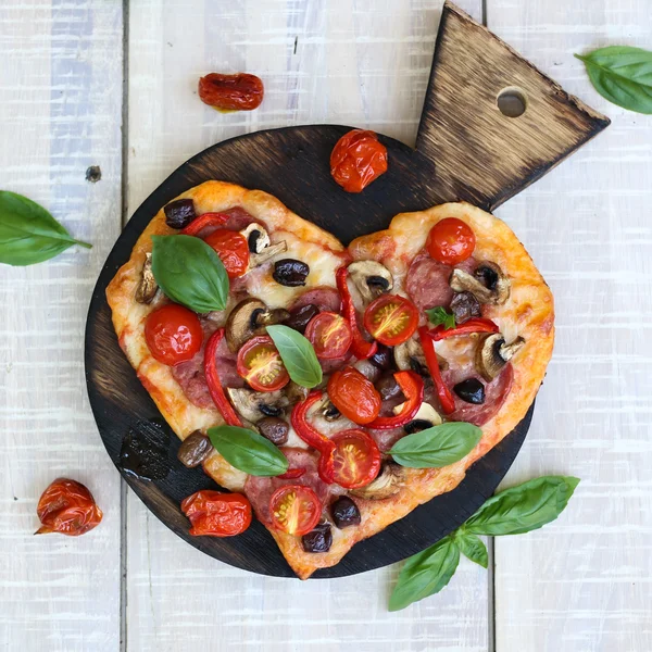 Pizza mit Paprika, Tomaten, Mozzarella, auf einem Holztisch. Valentinstag-Konzept — Stockfoto