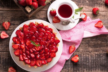 Çilek ve ahşap zemin üzerine krem şanti ile tart