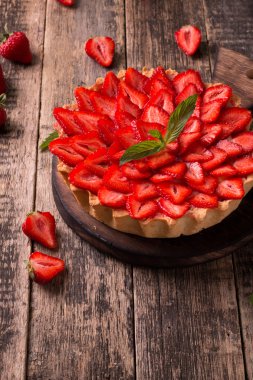 Çilek ve ahşap zemin üzerine krem şanti ile tart