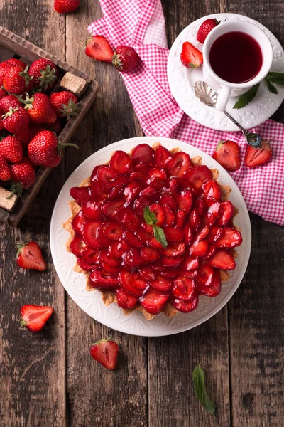 Tarta con fresas y crema batida sobre fondo de madera — Foto de Stock