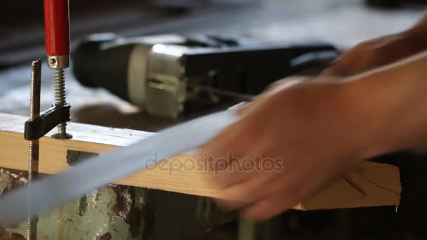 Uomo con puzzle elettrico che prepara il taglio di un pezzo di legno. Da vicino. . — Video Stock