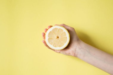 Limon sarı bir arka plan üzerinde kadının elinde