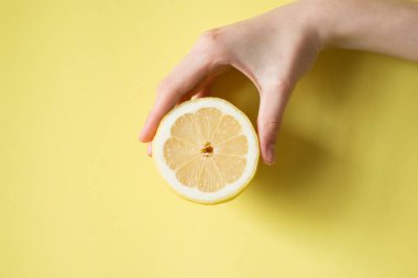 Limon sarı bir arka plan üzerinde kadının elinde