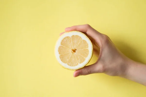 Лимонний в боку жінки на жовтому фоні — стокове фото