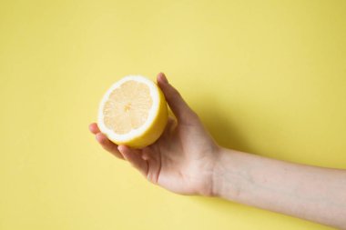 Limon sarı bir arka plan üzerinde kadının elinde