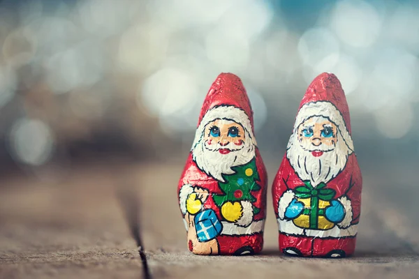Eski ahşap arka plan üzerinde bir çanta çikolata Noel Baba