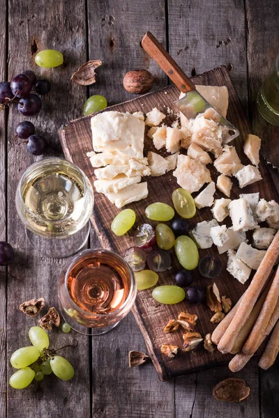 Peynir, şarap, meyve ve rustik ahşap masa snacks farklı türde. Natürmort kavramı