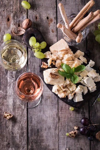 Peynir, şarap, meyve ve rustik ahşap masa snacks farklı türde. Natürmort kavramı