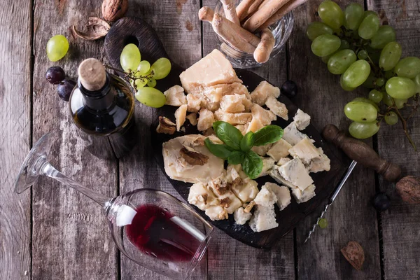 Peynir, şarap, meyve ve rustik ahşap masa snacks farklı türde. Natürmort kavramı