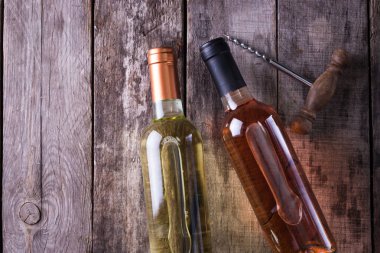 kırmızı, pembe ve beyaz şişe şarap ahşap masa arka plan üzerinde. Natürmort kavramı