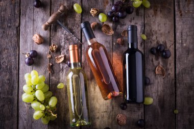 kırmızı, pembe ve beyaz şişe şarap ahşap masa arka plan üzerinde. Natürmort kavramı