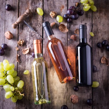 kırmızı, pembe ve beyaz şişe şarap ahşap masa arka plan üzerinde. Natürmort kavramı