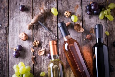 kırmızı, pembe ve beyaz şişe şarap ahşap masa arka plan üzerinde. Natürmort kavramı