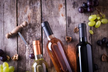 kırmızı, pembe ve beyaz şişe şarap ahşap masa arka plan üzerinde. Natürmort kavramı