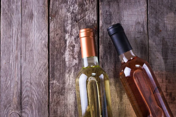 kırmızı, pembe ve beyaz şişe şarap ahşap masa arka plan üzerinde. Natürmort kavramı