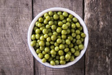 Yeşil bezelye l eski ahşap zemin, sağlıklı vegan gıda üzerine konserve