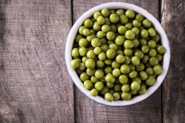 Yeşil bezelye l eski ahşap zemin, sağlıklı vegan gıda üzerine konserve