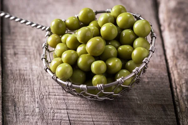 Guisantes verdes enlatados l sobre fondo de madera viejo, comida vegana saludable — Foto de Stock