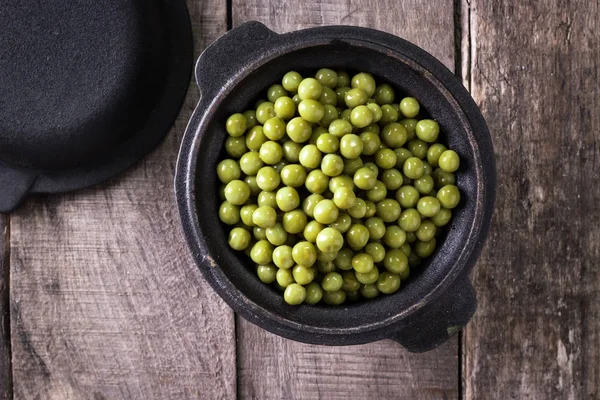Guisantes verdes enlatados l sobre fondo de madera viejo, comida vegana saludable — Foto de Stock