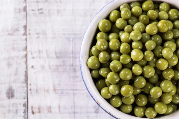 Guisantes verdes enlatados l sobre fondo de madera viejo, comida vegana saludable — Foto de Stock