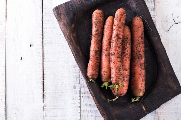 Bunch of fresh carrots with green leaves over wooden background. Vegetable. Food — Stock Photo, Image