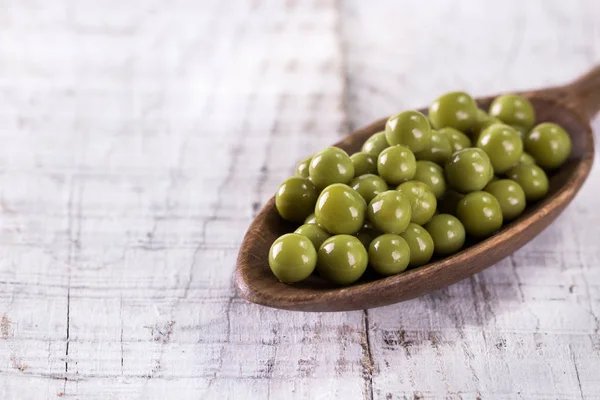 Guisantes verdes enlatados l sobre fondo de madera viejo, comida vegana saludable Imágenes De Stock Sin Royalties Gratis