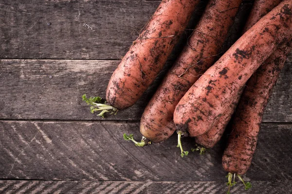 Manojo de zanahorias frescas con hojas verdes sobre fondo de madera. Hortalizas. Comida Imagen De Stock