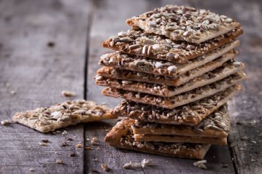 Gevrek crispbread ahşap arka plan üzerinde. Sağlıklı snack: gevrek gevrek tahıllı Mısır gevreği keten tohumu, susam, ayçiçeği tohumu protein ekmek bar.