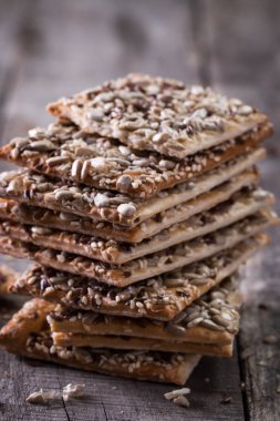 Gevrek crispbread ahşap arka plan üzerinde. Sağlıklı snack: gevrek gevrek tahıllı Mısır gevreği keten tohumu, susam, ayçiçeği tohumu protein ekmek bar.