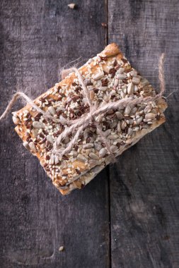 Gevrek crispbread ahşap arka plan üzerinde. Sağlıklı snack: gevrek gevrek tahıllı Mısır gevreği keten tohumu, susam, ayçiçeği tohumu protein ekmek bar.