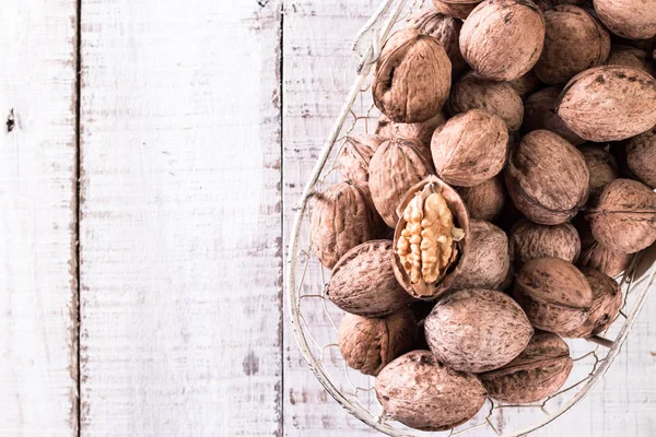 Nueces y nueces enteras sobre mesa rústica de madera vieja Imagen De Stock