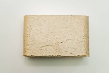 Alternatif yakıt, ekolojik yakıt, biyolojik yakıt. Odun talaşı sobaları için briketler. Isı çıkışı iyi olan bir yanık izi. Yeşil bir arka planda talaş briketleri.