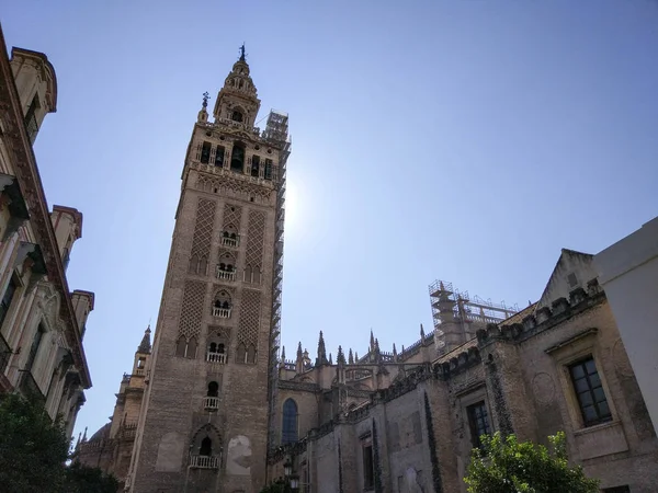 Vista Horizontal de la Giralda de Sevilla junto a Catedral de Sevilla Fotografia realizada en dia despejado sin nubes, a contra luz y cielo azul  - Fotografia realizada el 31 de Octubre del 2017, Sevilla, Andalucia, Espana, Europa