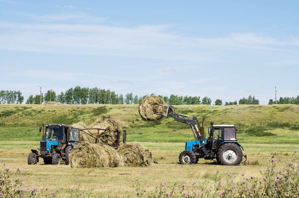 Loading of baled hay front loader
