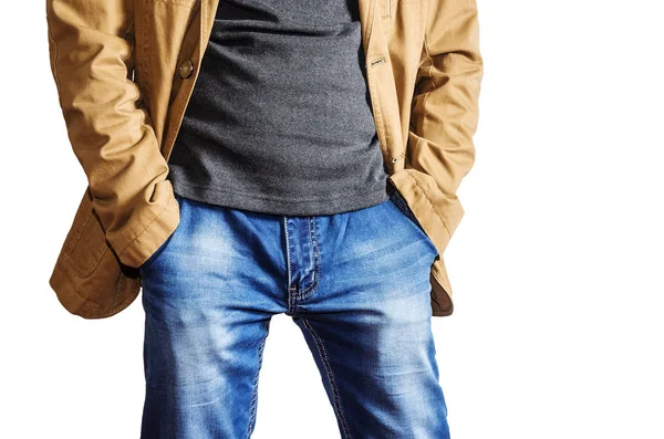 Uomo in giacca gialla e jeans blu che si tiene per mano nelle tasche — Foto Stock