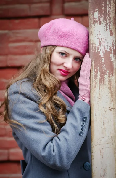 Ritratto di ragazza con berretto rosa e cappotto grigio-blu — Foto Stock