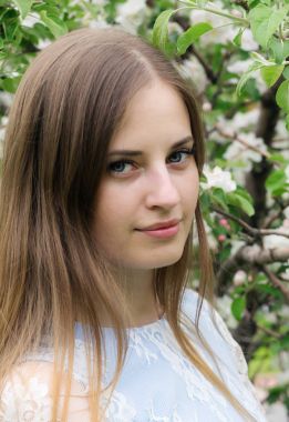 Çiçekli ağaçlar bir arka plan karşı poz kız