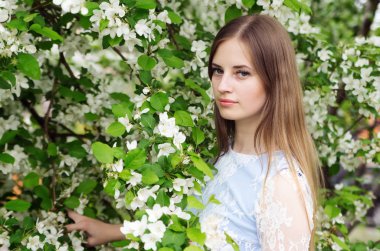 Çiçekli ağaçlar bir arka plan karşı poz kız