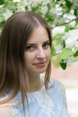 Çiçekli ağaçlar bir arka plan karşı poz kız