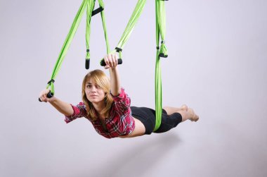 Kız bir hamakta yoga egzersizleri gerçekleştirir