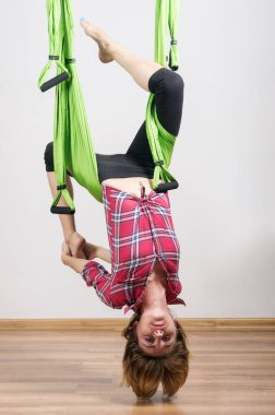 Kız bir hamakta yoga egzersizleri gerçekleştirir